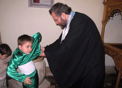طفل في بيت لحم يرتدي اللباس الأخضر استعداداً للمشاركة في احتفالات عيد الخضر